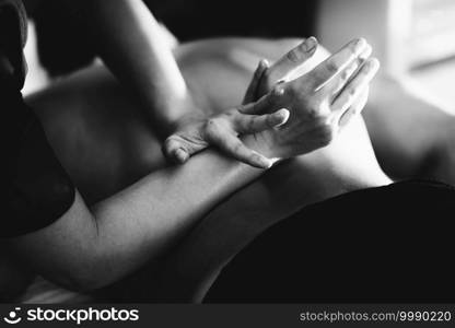 Physiotherapist massaging male patient with injured lower back muscle. Sports injury treatment.