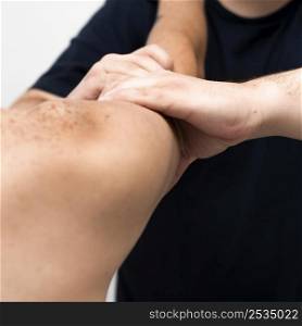 physiotherapist massaging man s arm