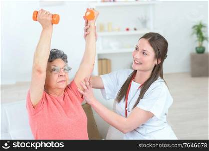 physiotherapist working with elderly patient in clinic