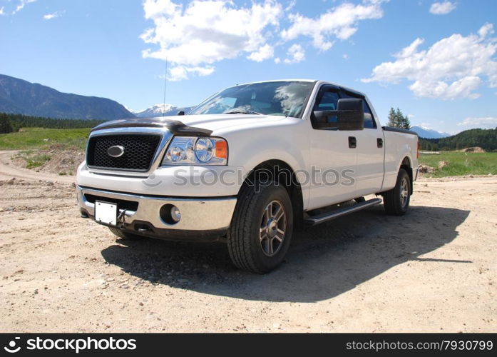 Pick-up truck on a dirt road in the mountains.