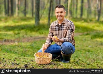 picking season and leisure people concept - happy smiling middle aged man with wicker basket and mushrooms in autumn forest. happy man with basket picking mushrooms in forest