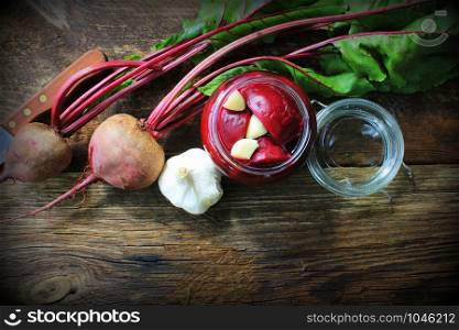 Pickled beets in the jar on a dark wood background .. Pickled beets in the jar on a dark wood background