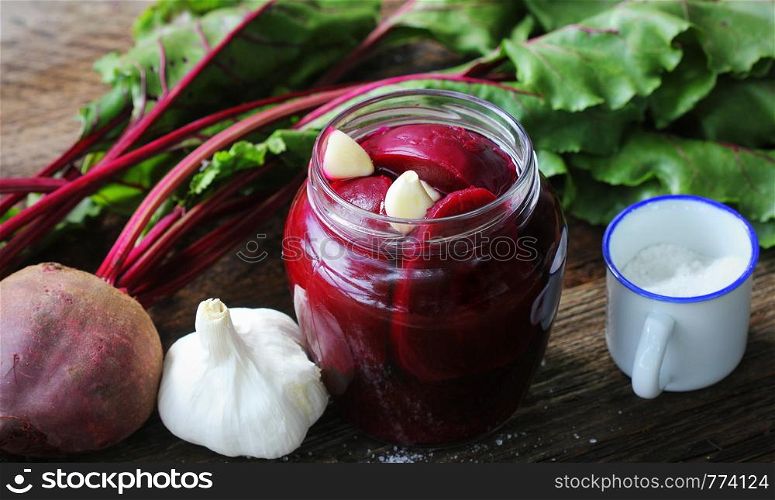 Pickled beets in the jar on a dark wood background .. Pickled beets in the jar on a dark wood background