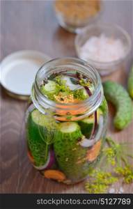Pickled cucumbers, homemade preserved on wooden table