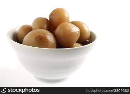 Pickled onions in a bowl over a white background