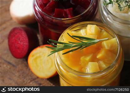 Pickled red, white, orange beet in glass jars. Variety pickles on rustic background .. Pickled red, white, orange beet in glass jars. Variety pickles on rustic background