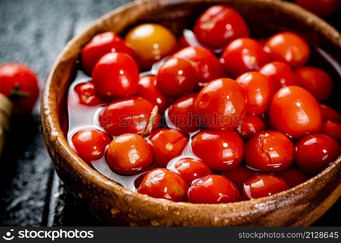 Pickling ripe homemade tomatoes on the table. On a black background. High quality photo. Pickling ripe homemade tomatoes on the table.