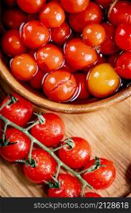 Pickling ripe tomatoes at home. On a wooden background. High quality photo. Pickling ripe tomatoes at home.