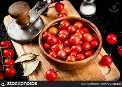 Pickling ripe tomatoes on a cutting board. On a black background. High quality photo. Pickling ripe tomatoes on a cutting board.