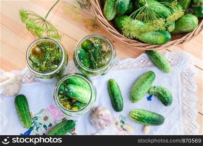 Pickling the cucumbers with home garden vegetables and herbs, fresh vegetables picked straight from field, collected on wooden table outdoors. View from above