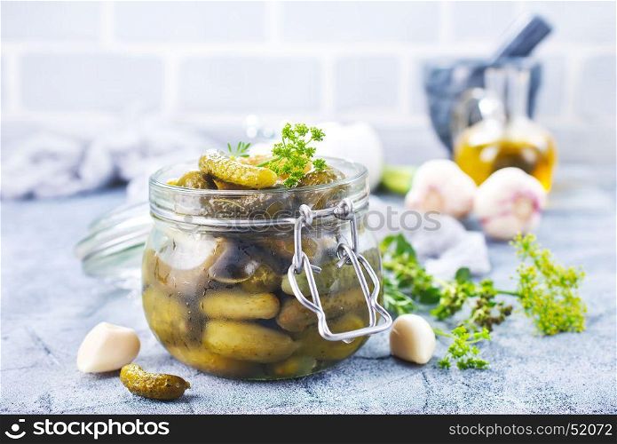 picled cucumber in glass bank and on a table