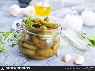 picled cucumber in glass bank and on a table
