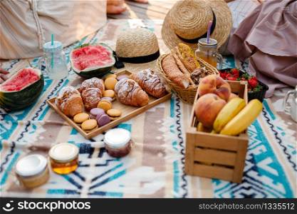 Picnic at the park. Fresh fruits, ice cold sparkling drinks and croissants on a hot summer day. Picnic lunch. selective focus.. Picnic at the park. Fresh fruits, ice cold sparkling drinks and croissants on a hot summer day. Picnic lunch. selective focus