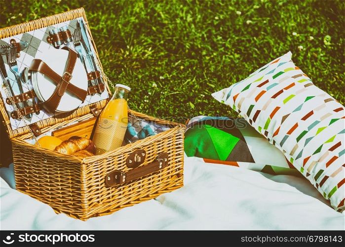 Picnic Basket Food On White Blanket With Pillows In Summer
