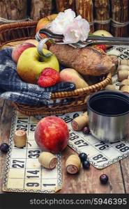 picnic basket with fruit,a blanket,and playing Lotto.