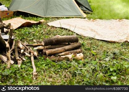 Picnic day with tourist green camping tent and pot on the fire at an outdoor campsite in the woods. Recreation and outdoor travel concept