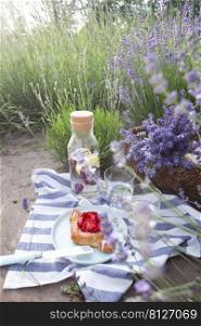 picnic in lavender field - lemonade with lemon and basil, a roll with a strawberry and a basket with lavender 