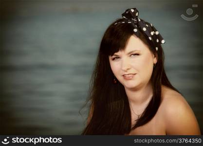 Picnic outdoors. Portrait of young woman with the sea in the background. Retro style.
