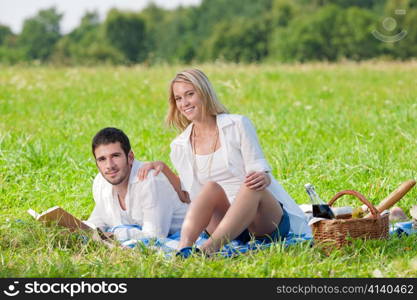 Picnic - Romantic happy couple in meadows nature reading book