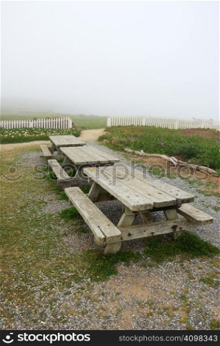 Picnic tables on California coast on a foggy day.