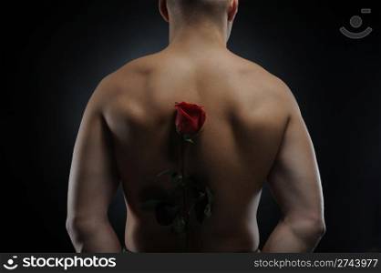 Picture a man holding a red rose behind his back. Isolated on white background