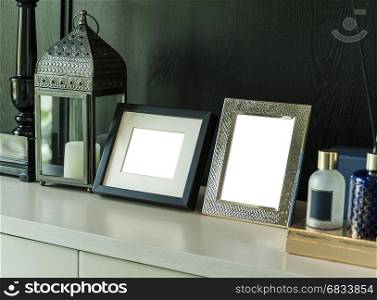Picture frame and candle lamp on a table in a contemporary room