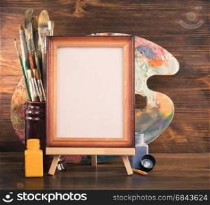 picture frame and paints on wood. picture frame and paints on wooden background