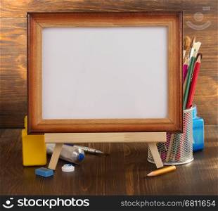 picture frame and paints on wooden background
