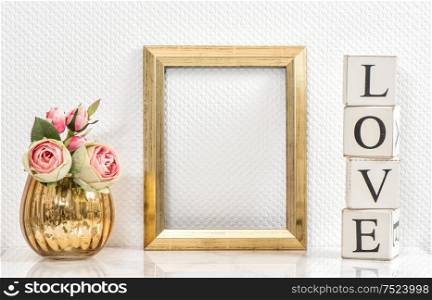 Picture frame and pink roses. Valentines Day concept. Mock up with golden frame and flowers with space for your picture or text