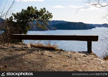 Picture of a lonely old wooden bench with view over the sea