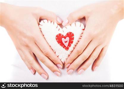 Picture of a small white heart in hands, female holds handmade sewn soft toy, macro, shallow dof, woman with Valentine gift, happy girl smiling, conceptual image of health care or love