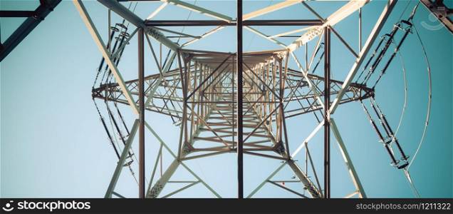 Picture of an electrical tower or pylon, blue sky in the background. Power grid or smart grid.