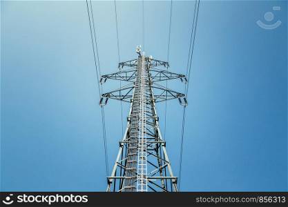 Picture of an electrical tower or pylon, blue sky in the background. Power grid or smart grid.