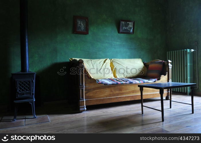 picture of an old living room with green wall and wood burning stove