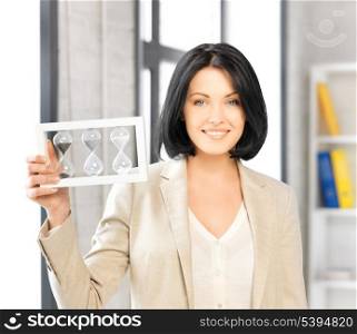 picture of attractive businesswoman holding hourglass.