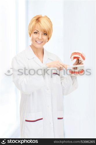 picture of attractive female doctor with toothbrush and jaws.