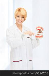 picture of attractive female doctor with toothbrush and jaws.
