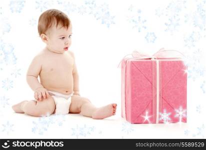 picture of baby boy in diaper with big gift box and snowflakes
