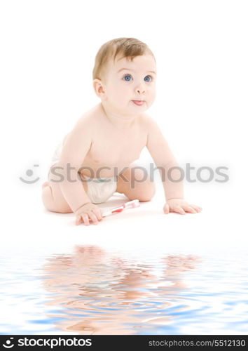 picture of baby boy in diaper with toothbrush sticking tongue out