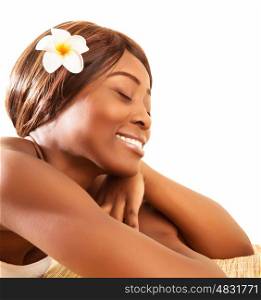 Picture of beautiful African woman with closed eyes enjoying dayspa, attractive female lying down on massage table with franjipani flowers in dark hair, luxury spa salon, beauty treatment&#xA;