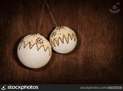 Picture of beautiful Christmas decoration, two white xmas bubbles hanging and isolated on dark grunge background, festive home ornament, retro style photo, New Year traditional adorning