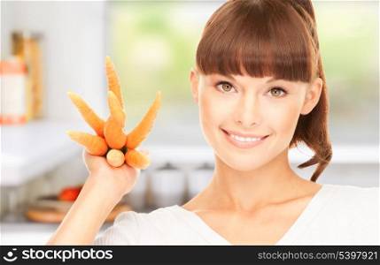 picture of beautiful housewife with carrots at the kitchen
