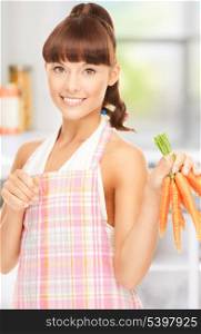 picture of beautiful housewife with carrots at the kitchen
