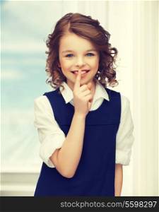 picture of beautiful pre-teen girl showing hush gesture