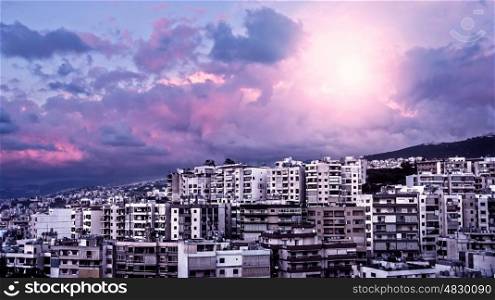Picture of beautiful purple sunset over city, peaceful landscape, architecture in Lebanon, arabian buildings, panorama of downtown, cloudy sky, pink sunrise, travel and tourism concept
