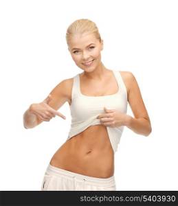 picture of beautiful sporty woman pointing at her abs