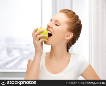picture of beautiful teenage biting a green apple