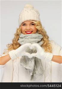picture of beautiful woman in a winter clothes showing heart..