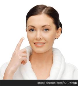 picture of beautiful woman in bathrobe applying creme