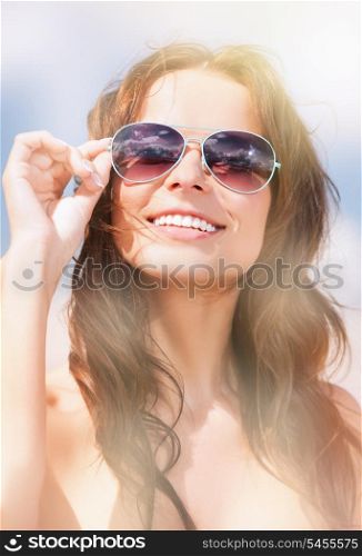 picture of beautiful woman in sunglasses on a beach